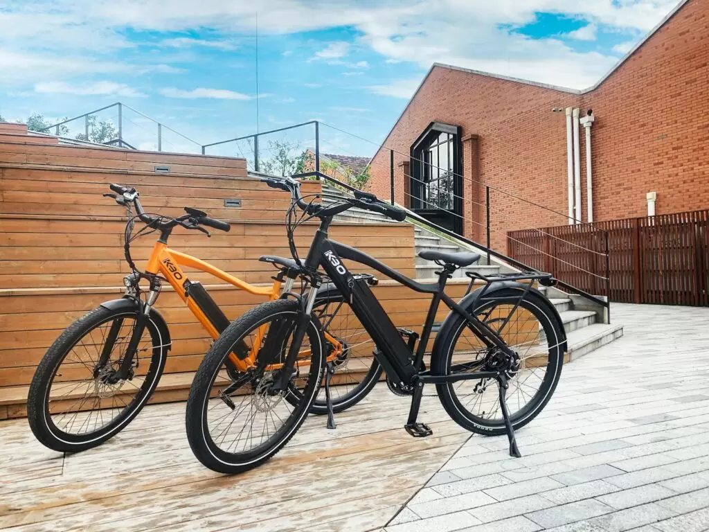 black and brown bicycle parked beside brown concrete building during daytime
